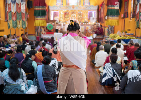 Un adorateur entrant dans le temple bouddhiste de Sherpa dans Queens s'arrête un moment de prière et de méditation. Banque D'Images