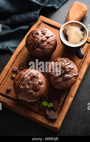 Muffins au chocolat noir et tasse de café espresso noir sur sol en bois servant de sélection. Vue d'en haut Banque D'Images