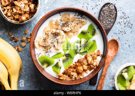 Tropical Fruit kiwi, banane bol à céréales, d'avoine graines de chia et de yaourts. Nettoyer alimentaires, les régimes, l'alimentation et le mode de vie végétarien sain concept Banque D'Images