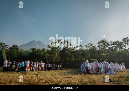 Yogyakarta, Indonésie. Août 11, 2019. Musulmans indonésiens effectuer l'Eid al-Adha prière avec arrière-plan le Mont Merapi à Glagaharjo village de Yogyakarta, Indonésie, le 11 août 2019. Les musulmans du monde entier se préparent à célébrer l'Aïd al-Adha ou fête du sacrifice qui marque la fin de l'Assemblée haj pèlerinage. (Photo par Rizqullah Hamiid Saputra/Pacific Press) Credit : Pacific Press Agency/Alamy Live News Crédit : Pacific Press Agency/Alamy Live News Banque D'Images