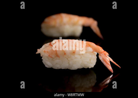 Avec des sushi, crevette rose Langoustine Homard mini avec une queue sur un fond noir la réflexion. La cuisine japonaise est un plat de riz et de matières seafoo Banque D'Images