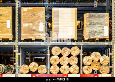 Étagères du magasin-entrepôt meubles et marchandises. Rempli d'entrepôt de marchandises à vendre. Boîtes avec détails de meubles et des rouleaux avec les textiles, c Banque D'Images