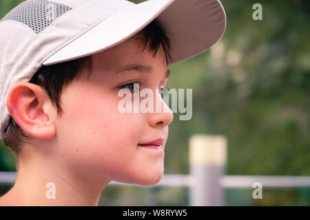 Portrait d'un adorable petit garçon de 8 ans à l'extérieur portant une casquette de baseball gris Banque D'Images