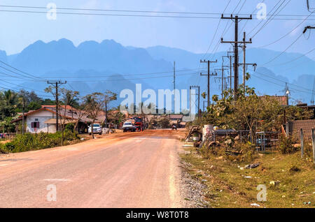 Village laotien à conduire et ses collines à l'horizon Banque D'Images