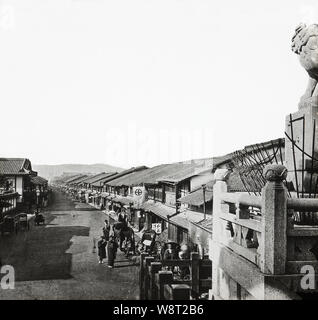 [ 1870 - Japon ] - Kyoto Gion, le quartier des divertissements de Gion à Kyoto, vu de l'étapes de Yasaka. La rue est bordée d'une multitude de maisons de thé où les clients peuvent profiter de la nourriture, de la danse et de la musique. Poteaux électriques ne disposent pas encore de la ligne de rue. Société d'électricité de Kyoto, Kyoto Dento Programmation, a démarré en juillet 1889 (22), afin de Meiji cette photo a été prise avant cette date. 19e siècle vintage lame de verre. Banque D'Images