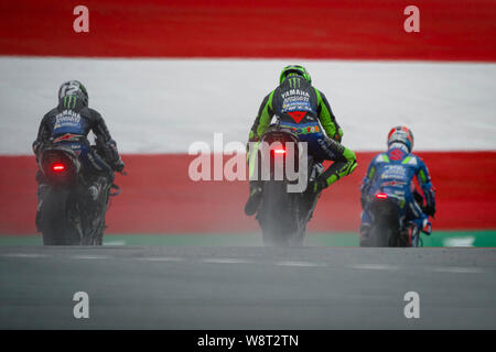 Le Monster Energy Yamaha MotoGP coureur espagnol Maverick Viñales (L), Monster Energy Yamaha du pilote Italien de MotoGP Valentino Rossi (C) et de l'équipe Suzuki du Ecstar coureur espagnol Alex rin (R) ride dans la voie des stands pendant la session d'échauffement avant de la MotoGP course de Grand Prix. Banque D'Images