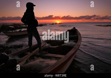 Les bateaux de pêche et un pêcheur à la plage de Nkhotakota, Malawi Banque D'Images