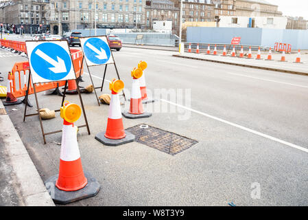 Signes et cônes de signalisation indiquant la fermeture d'un laneof une large rue car des travaux routiers dans le centre d'une ville Banque D'Images