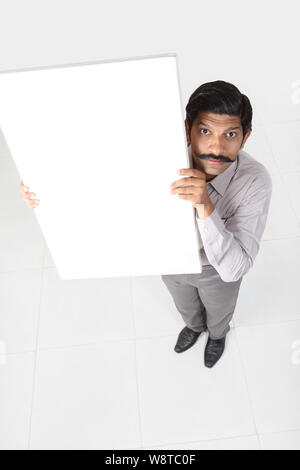 Businessman showing a blank placard et à la peur Banque D'Images