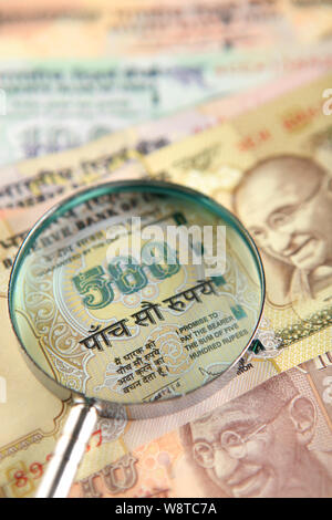 Cinq cent rupee remarque regarde à travers une loupe Banque D'Images