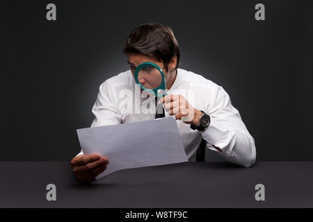 Businessman à la loupe à travers un document Banque D'Images