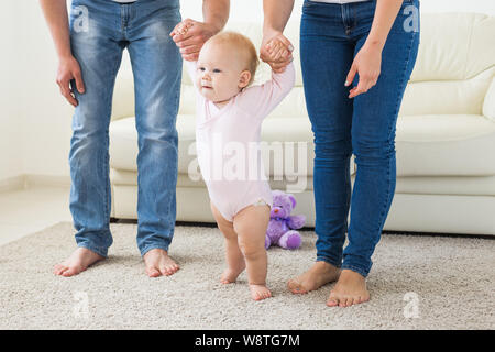 La famille, les enfants et la parentalité concept - enseignement parents baby girl de marcher Banque D'Images