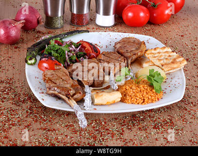 Pirzola Brochettes de viande et de tomates et d'oignons rouges sur une plaque blanche Banque D'Images