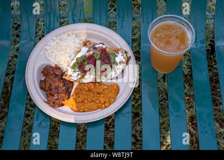 Repas méditerranéen sur du papier blanc sur plaque de banc de parc accompagné d'un verre de bière (vue de dessus, un jour ensoleillé Banque D'Images