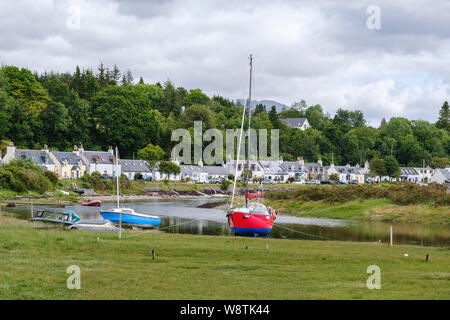 Lochcarron village, NW des Highlands d'Écosse. Maisons de la rue principale avec des bateaux sur le Loch Carron en premier plan Banque D'Images