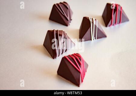 Chocolat pralines vegan colorés en verre sur plateau. Banque D'Images