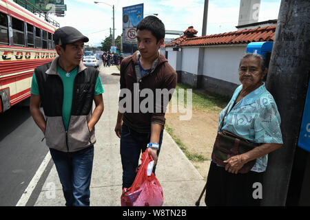 2 août 2019, La Reforma, San Marcos, Guatemala : Lisardo Perez, 19 ans, se promène le long de son cousin Eduardo, à l'extérieur de l'Aéroport International de Guatemala City où il a été expulsé récemment, et commencer à retourner à sa maison dans la ville La Reforma, Guatemala.Â après 8 années de baisse des prix du café, 4 en dehors d'un travail régulier de son père, et 3 ans en regardant son jeune frère Edgar Giovani souffrent d'une maladie qui debilitatingÂ la gauche dans la famille de la dette médicale, ils ont mis tous leurs espoirs dans Lisardoâ€" prendre un prêt contre 8 000 $ pour payer un passeur pour l'emmener vers les États-Unis, où ils espéraient qu'il sâ€™d m Banque D'Images