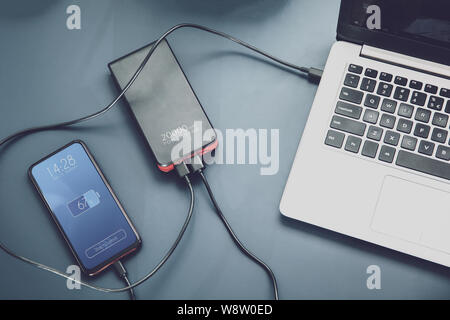 Les frais bancaires d'alimentation puissante deux périphériques en même temps via USB-C connexion. Sur l'écran de l'interface a été créé en logiciel graphique. Banque D'Images