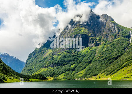 Crête de montagne verte au-dessus du petit village de Naeroy fjord, Aurlan, comté de Sogn og Fjordane, Norvège Banque D'Images