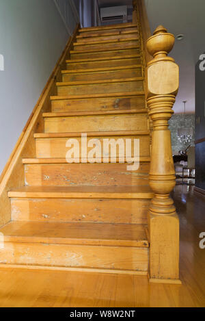 Poteau et escalier en bois de pin menant à l'étage à l'intérieur d'une ancienne maison en pierre de style cottage de 1820. Banque D'Images