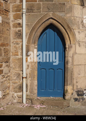 Porte en bois voûté bleu dans la pierre porte voûtée situé dans mur avec échappement peint en blanc, près de la cathédrale en ruine à St Andrews, East Neuk, Fife, Scotland Banque D'Images