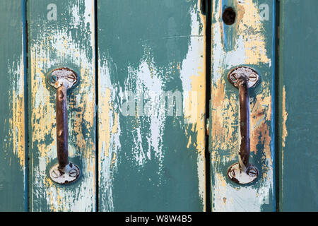 Close-up de deux poignées en fer forgé sur distressed aqua green armoire en pin portes à l'intérieur d'une ancienne demeure victorienne 1900 maison de style néo-Queen Anne Banque D'Images