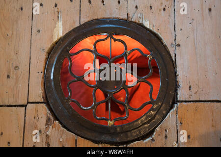 Close-up de la circulaire en fonte antique grille pour l'air et la circulation de chaleur installés dans des planches de bois de pin s'est évanouie à l'étage étage maison ancienne à l'intérieur Banque D'Images