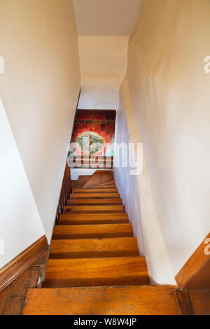 Escalier en bois de pin menant au rez-de-chaussée à l'intérieur d'une ancienne maison en pierre de style cottage de 1820. Banque D'Images