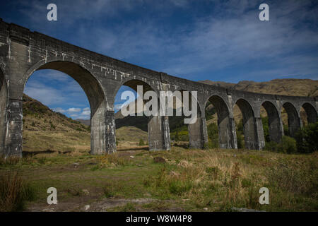 Vue du sol du béton viaduc de Glenfinnan rendu célèbre dans les films de Harry Potter portant le Poudlard Express Le train à vapeur Jacobite aka Banque D'Images