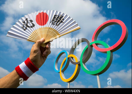 Londres - le 19 avril 2019 : un ventilateur décoré de caractères kanji japonais épelant hissho (certains victoire) à un ensemble d'anneaux olympiques. Banque D'Images