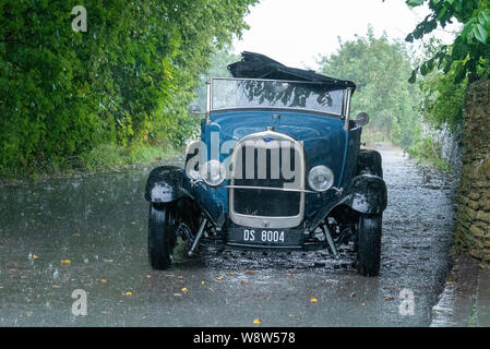 1929 Ford Roadster chauffeur pris dans de fortes pluies, Frome Somerset UK Banque D'Images