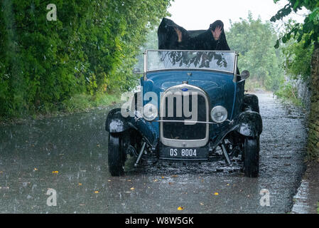 1929 Ford Roadster chauffeur pris dans de fortes pluies, Frome Somerset UK Banque D'Images