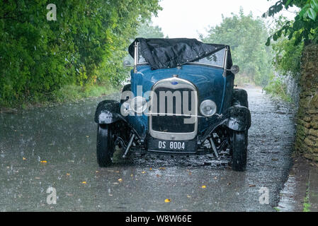 1929 Ford Roadster chauffeur pris dans de fortes pluies, Frome Somerset UK Banque D'Images