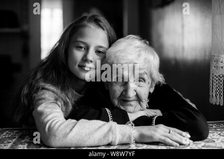 Un peu cute girl hugs sa grand-mère. Portrait noir et blanc. Banque D'Images