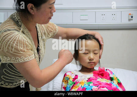 Jeune fille de 12 ans, Han Bingbing, droit qui souffre d'une tumeur géante dans son ventre est assisté par sa mère à l'hôpital du cancer de Fuda, dans la ville de Guangzhou Banque D'Images