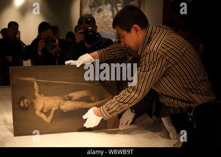 Un membre du personnel présente un tableau de peintre français Pascal Dagnan-Bouveret, au Musée d'Art de Beijing dans le Monument du millénaire de la Chine de Pékin à Banque D'Images