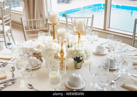 Photo de bougies piliers blanches en candélabre et fleur blanche bouquets sur une table de mariage Banque D'Images