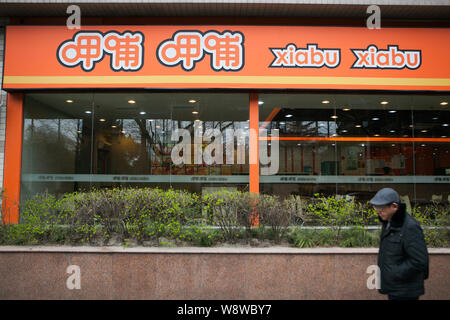 --FILE--un piéton passe devant un restaurant de Xiabu Xiabu hotpot à Shanghai, Chine, 20 mars 2014. Xiabuxiabu Catering Management, un bar chinois- Banque D'Images