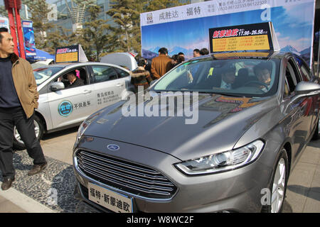 --FILE--visiteurs essayer ou regarder une Ford Mondeo lors d'une auto show de la ville de Qingdao, province du Shandong, Chine de l'est 15 mars 2014. Ford Motor Co. Banque D'Images