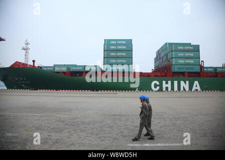 --FILE--travailleurs chinois passent devant un porte-conteneurs chargés de conteneurs de Chine voyage dans un port de la ville de Haikou, province de Hainan, Chine du Sud 23 Banque D'Images