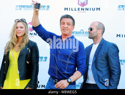 Acteur et réalisateur Sylvester Stallone, centre, prend vos autoportraits en regard de l'actrice de mixed martial arts Ronda Rousey, à gauche, et l'acteur britannique Jason S Banque D'Images