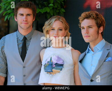 (De gauche) l'acteur australien Liam Hemsworth, actrice américaine Jennifer Lawrence et l'acteur Anglais Sam Claflin posent à un photocall pour leur film, Les Banque D'Images
