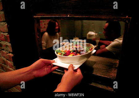 Une serveuse sert de la nourriture aux clients à la première prison-restaurant à thème dans la région de Tianjin, Chine, 6 septembre 2014. Un restaurant spécial sur le modèle de priso Banque D'Images