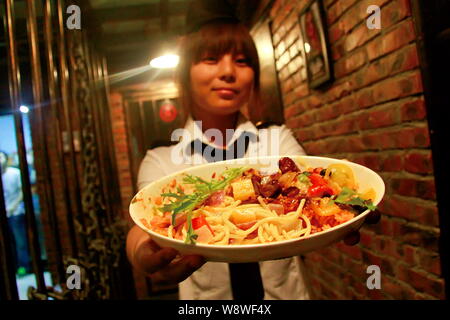 Une serveuse sert de la nourriture aux clients à la première prison-restaurant à thème dans la région de Tianjin, Chine, 6 septembre 2014. Un restaurant spécial sur le modèle de priso Banque D'Images