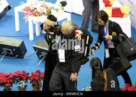 Yuzuru Hanyu du Japon, à gauche, est porté par son entraîneur après une collision avec Yan Han de la Chine pendant la Coupe de Chine de Lexus 2014 ISU Grand Prix of Figure Banque D'Images