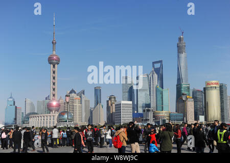 --FILE--touristes visitent la promenade sur le Bund pour voir l'horizon de la financier de Lujiazui à Pudong, Shanghai, Chine, 21 mars 2014. C Banque D'Images