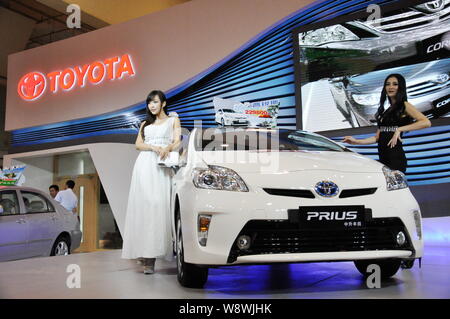 --FILE--modèles posent avec une Toyota Prius hybride voiture en cas d'exposition d'automobiles dans la ville de Qingdao, province du Shandong, Chine de l'est 14 septembre 2012. Banque D'Images