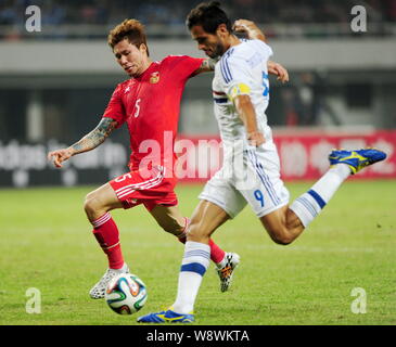 Zhang Linpeng de Chine, gauche, défis Roque Santa Cruz du Paraguay au cours d'un match de football amical à Changsha city, Hunan province du centre de la Chine Banque D'Images