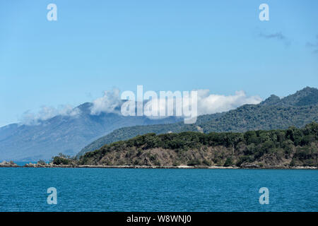 Les nuages blancs moelleux accrocher au-dessus de la plage de la côte pittoresque le long de Cpt Cook Highway entre Port Douglas et Cairns, Far North Queensland, FNQ, QLD Banque D'Images