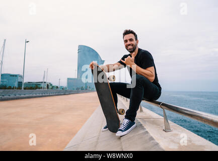 Siège avec la planche à roulettes sur la terrasse de la mer la ville moderne Banque D'Images